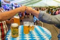 A group of young people Friends toasting with glasses of beer at the Oktoberfest germany Soft focus. Shallow DOF