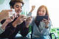 A group of young people having fun while watching and playing games on mobile phone together Royalty Free Stock Photo