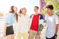 Group of young people having fun together outdoors. Portrait of multiethnic students laughing at the city.