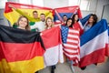 Group of young people holding international flags of many countries in the classroom