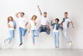 Group of young people in jeans jumping near wall Royalty Free Stock Photo