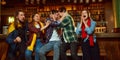 Group of young people, men and women watching match at pub. Fans emotionally cheering up favourite sport team Royalty Free Stock Photo