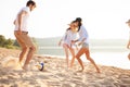 Group of young people playing with ball at the beach. Young friends enjoying summer holidays on a sandy beach Royalty Free Stock Photo