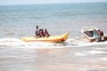 Group of young people riding banana boat water sport.Anjuna beach,Goa,India.14 December 2019 Royalty Free Stock Photo