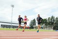 Group of young people running on the track field Royalty Free Stock Photo