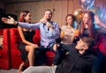 Group of young people singing into microphone at party,celebrating birthday, karaoke Royalty Free Stock Photo