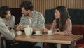 Group of young people sitting at a cafe, talking and drinking tea Royalty Free Stock Photo