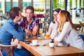 Group of young people sitting at a cafe, talking and enjoying Royalty Free Stock Photo