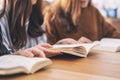 People sitting and enjoyed reading books together on wooden table