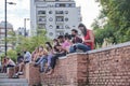 Group of young people sitting outdoors at a reading activity, using face masks