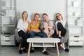 Group of young people sitting on sofa and talking at home. Cheerful young people in casual wear laughing sitting on Royalty Free Stock Photo