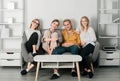 Group of young people sitting on sofa and talking at home. Cheerful young people in casual wear laughing sitting on Royalty Free Stock Photo