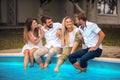 Young people sitting on the swimming pool Royalty Free Stock Photo