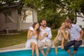 Group of young people sitting on the swimming pool. Day with friends Royalty Free Stock Photo