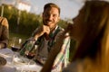 Group of young people sitting by the table and drinking red wine in the vineyard Royalty Free Stock Photo