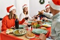 Group of young people smiling happy celebrating christmas drinking wine at home Royalty Free Stock Photo