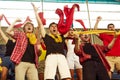 Group of young people, sports fans, enthusiasts shouting, cheering up favourite team during game, match Royalty Free Stock Photo