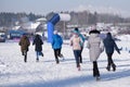 Group of young people in sportswear cheering athletic young man crossing finish line in winter snowy park outdoors Royalty Free Stock Photo