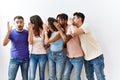 Group of young people standing together over isolated background hand on mouth telling secret rumor, whispering malicious talk Royalty Free Stock Photo