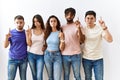 Group of young people standing together over isolated background pointing up looking sad and upset, indicating direction with Royalty Free Stock Photo