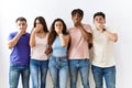 Group of young people standing together over isolated background shocked covering mouth with hands for mistake Royalty Free Stock Photo