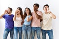 Group of young people standing together over isolated background shouting and screaming loud to side with hand on mouth Royalty Free Stock Photo