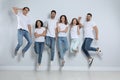 Group of young people in stylish jeans jumping near wall Royalty Free Stock Photo