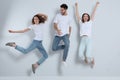 Group of young people in stylish jeans jumping near wall Royalty Free Stock Photo