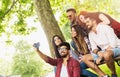 Group of young people taking a selfie outdoors on the bench, having fun Royalty Free Stock Photo