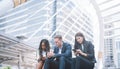 Group of young people use their phones in city. Royalty Free Stock Photo