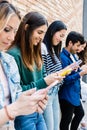 Group of young people using mobile phone device together outdoors Royalty Free Stock Photo