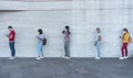 Group of young people waiting for going inside a shop market while keeping social distance in line during coronavirus time - Royalty Free Stock Photo