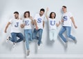 Group of young people wearing T-shirts with letters near wall. Christian religion
