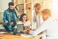 Group of young people work together. Man is using laptop, guy is talking on his cell phone. Royalty Free Stock Photo