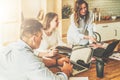 Group of young people working together.Man is using laptop,girls looking on screen of laptop,discussing business plan. Royalty Free Stock Photo