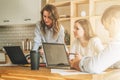 Group of young people working together. Man is using laptop, girls looking on screen of laptop, discussing business plan. Royalty Free Stock Photo