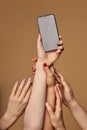 group of young people& x27;s hands with smartphone isolated on beige background Royalty Free Stock Photo