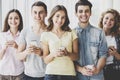 Group of Young Positive Friends Holding Phones Royalty Free Stock Photo