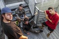 Group of young rappers posing on the metal stairs