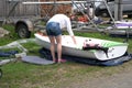 A group of young sailors readying their sailboats for sail .