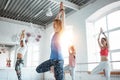 Group of young slim woman practice yoga exercise indoor class. People doing fitness together Royalty Free Stock Photo