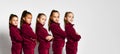 Group of young smiling girls gymnasts in dark red velvet sport costumes standing and posing