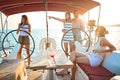 Group of young people sailing on boat together and enjoy at sunset on vacation