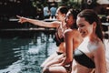 Group of Young Smiling Women Sitting at Poolside Royalty Free Stock Photo