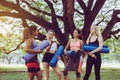 Group of young sporty girl holding yoga mats and talking together at park,Happy and smiling,Relaxing time