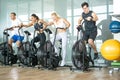 Group of young sporty people doing exercises on elliptical machine at gym Royalty Free Stock Photo