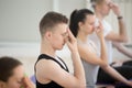 Group of young sporty people in nadi shodhana pranayama pose Royalty Free Stock Photo