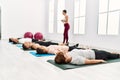 Group of young sporty people relaxed with close eyes lying on the floor on yoga class at sport center