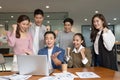 Group of young Startup coworkers working together looking at laptop and celebrating with success they job at office Royalty Free Stock Photo