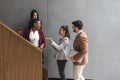 Group of young successful business people on stairs of office building happy with new ideas and satisfied with work support each